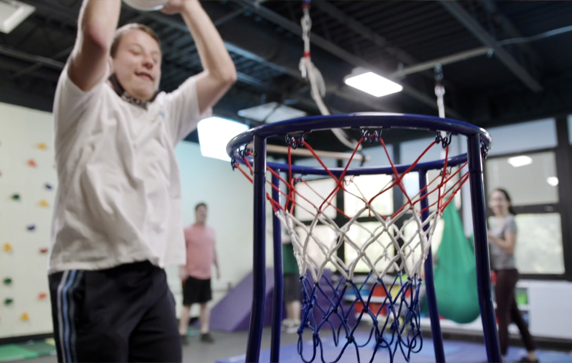 Boy playing basketball in activity room of KidsLink Neurobehavioral Center